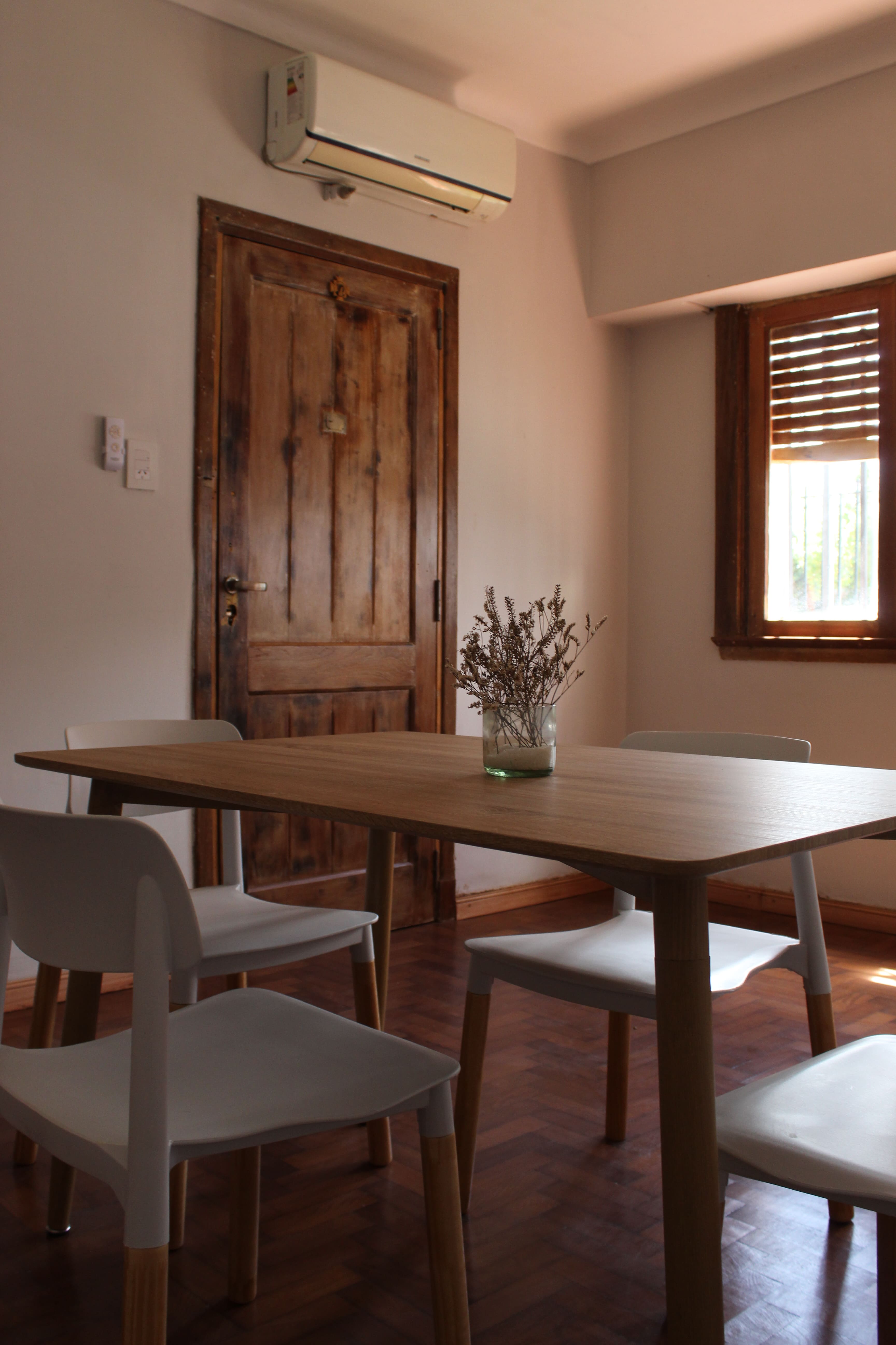 Living comedor con mesa de madera y aire acondicionado